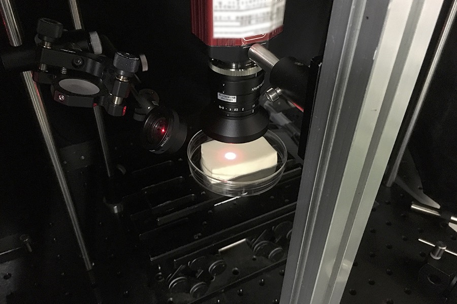 レーザ光学系を用い豆腐の凝固過程を光で測っている様子の画像
